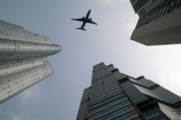 Fototapeta na wymiar An airplane flying over a skyscraper in Haeundae, Busan, South Korea.