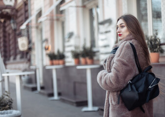 Fashion woman in a luxurious fur coat walking in city - Powered by Adobe