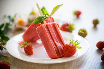 homemade strawberry ice cream on a stick made from fresh strawberries in a plate