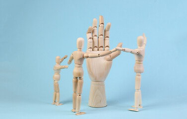 Wooden puppets and hand on a blue background.