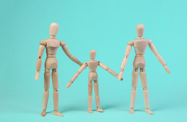 Happy family concept. Wooden puppets of mother father and child on blue background