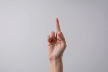 Hand pointing up middle finger, concept of rude hand sign or hand gesture, isolated