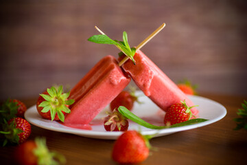 homemade strawberry ice cream on a stick made from fresh strawberries in a plate