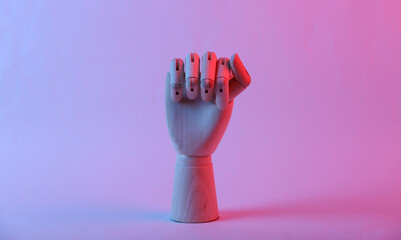 Wooden hand shows fist, feminism symbol in pink blue gradient neon light