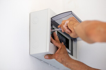 The white iron box is mounted on the wall and the wires are embedded inside the wall.