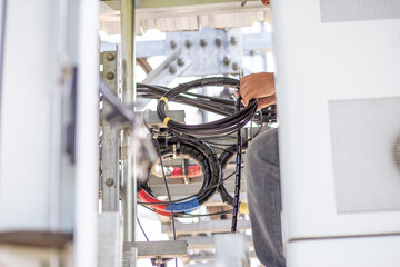 Installing a new mobile network cable behind the phone control cabinet To upgrade to a 5G network, the work of electrical engineers in Thailand