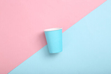 Empty blue cardboard coffee cup on pink blue background. Minimalism