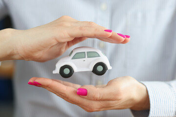 Toy car in female hands of insurance agent