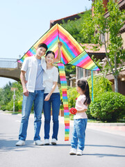 Happy family of three flying kites outdoors