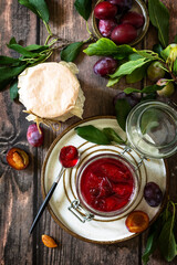 Homemade preservation. Delicious plum jam on a rustic wooden table. Top view flat lay background.