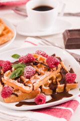 Waffles with raspberries and chocolate cream.