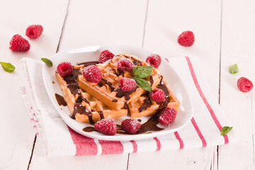 Waffles with raspberries and chocolate cream.