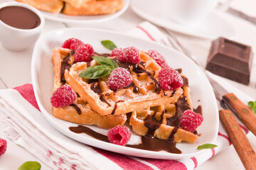 Waffles with raspberries and chocolate cream.