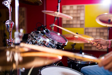 Fototapeta na wymiar Attractive Teenage Drummer with Drumsticks in recording studio
