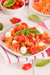 Fusilli pasta with cherry tomatoes and mozzarella cheese.