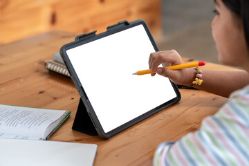 Close-up of a woman student hand holding a pen working using a blank white screen tablet sitting at...