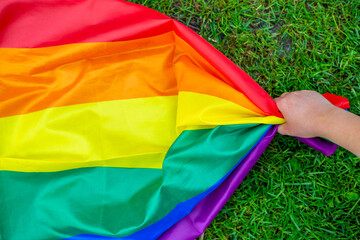 Group of people holding rainbow pride flag in a hands, gay and lesbian concept, LGBTQ