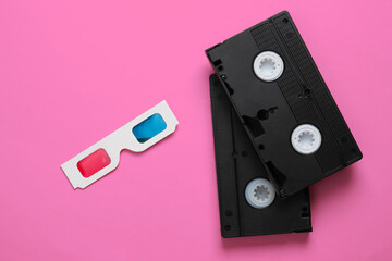 Anaglyph disposable paper 3d glasses and video cassette on yellow background. Retro media,...