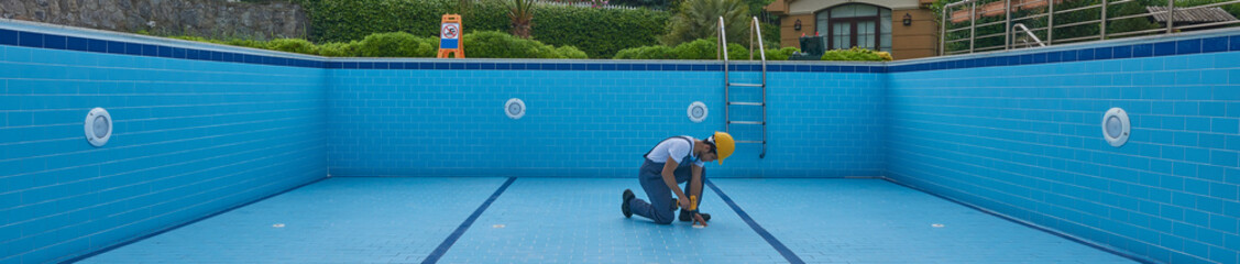 Repairman is repairing pool with equipment. Pool maintenance style. - Powered by Adobe