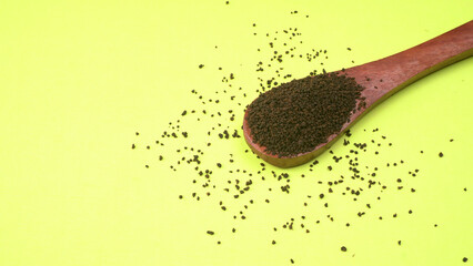 Black Tea Powder or dry dust tea powder, chai patti isolated in wooden bowl with Cardamom, Clove...