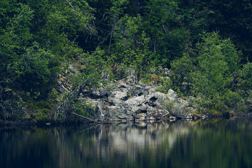 Fototapeta na wymiar Rocks by the Middle Tjuvåstjern Lake up in the Totenåsen Hills, Norway.