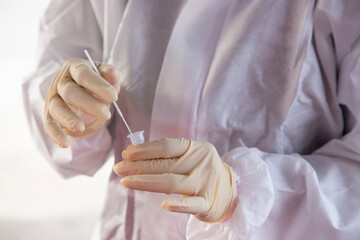 Obraz premium Medical officer mix a swab test sample with liquid to do a RTK-Ag test for Covid-19 virus.