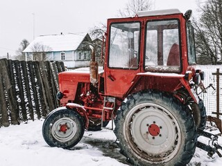 Red tractor in a winter Russian village