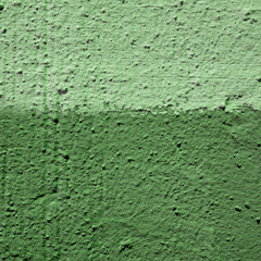 Volumetric plaster green background with two hues of green. Abstract building wall, two color wall.