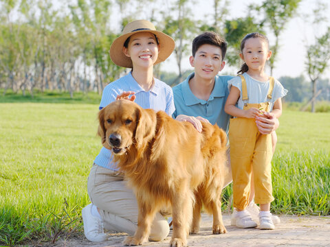 Happy family of three and pet dog in the park