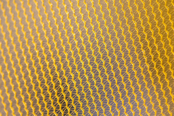 Yellow mesh structure in close-up with backlight on shine morning shows abstract pattern of...