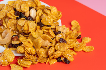 Cornflakes honey caramel homemade with grains, currant, cashew nut, dried strawberries and white sesame healthy food snack on a white plate close up and Macro copy space.