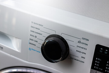 Close-Up white washing machine control panel In laundry room.