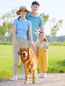 Happy family of three and pet dog in the park