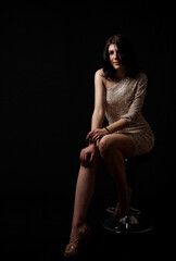 Fototapeta na wymiar young beautiful girl posing sitting on chair in the studio