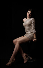 young beautiful girl posing sitting on chair in the studio