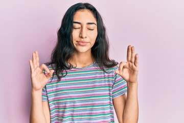 Hispanic teenager girl with dental braces wearing casual clothes relax and smiling with eyes closed doing meditation gesture with fingers. yoga concept.