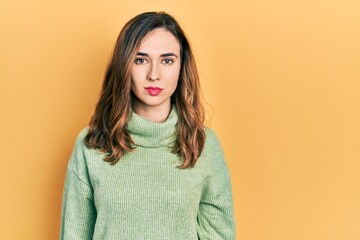 Young hispanic girl wearing casual clothes with serious expression on face. simple and natural looking at the camera.