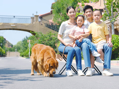 Happy family of four and pet dog in outdoor photo