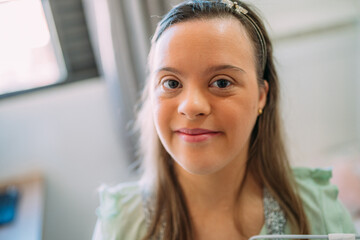 Close up portrait of friendly young Latin woman with down syndrome. © Nexa