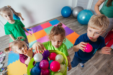 Fototapeta na wymiar Sporty kids enjoying activities with young teacher
