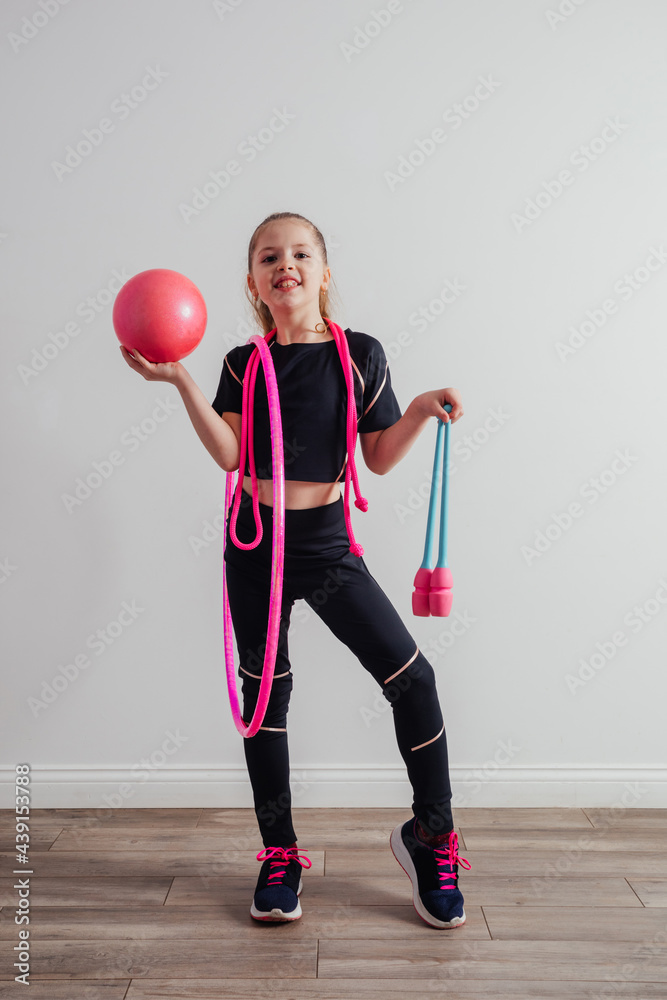 Wall mural Young professional gymnast girl posing with equipment