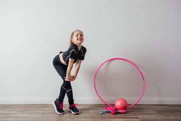 Young professional gymnast girl posing with equipment