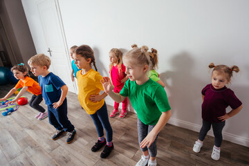 Group of children doing gymnastics in kindergarten or daycare