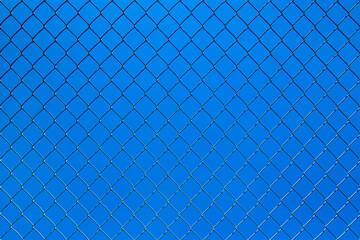 Fototapeta premium Wire mesh fence with a blue sky