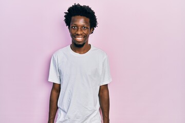 Young african american man wearing casual white t shirt with a happy and cool smile on face. lucky person.