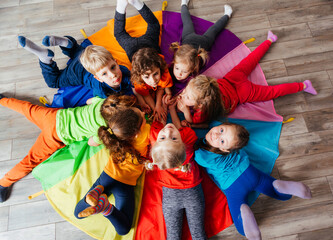 Cheerful children playing team building games on a floor - 439155925