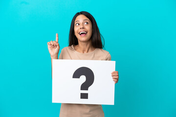 Young woman over isolated background holding a placard with question mark symbol and thinking