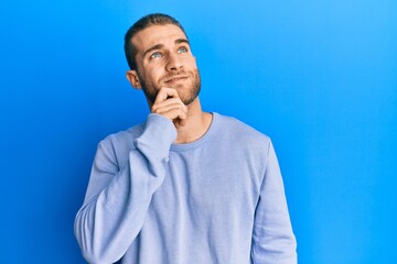 Young caucasian man wearing casual clothes thinking concentrated about doubt with finger on chin...