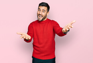 Young hispanic man wearing casual clothes smiling cheerful offering hands giving assistance and acceptance. © Krakenimages.com