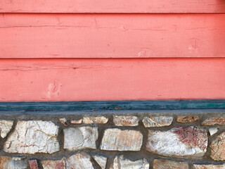 vintage retro style aged weathered wood panel siding wall with natural rock stone foundation facade